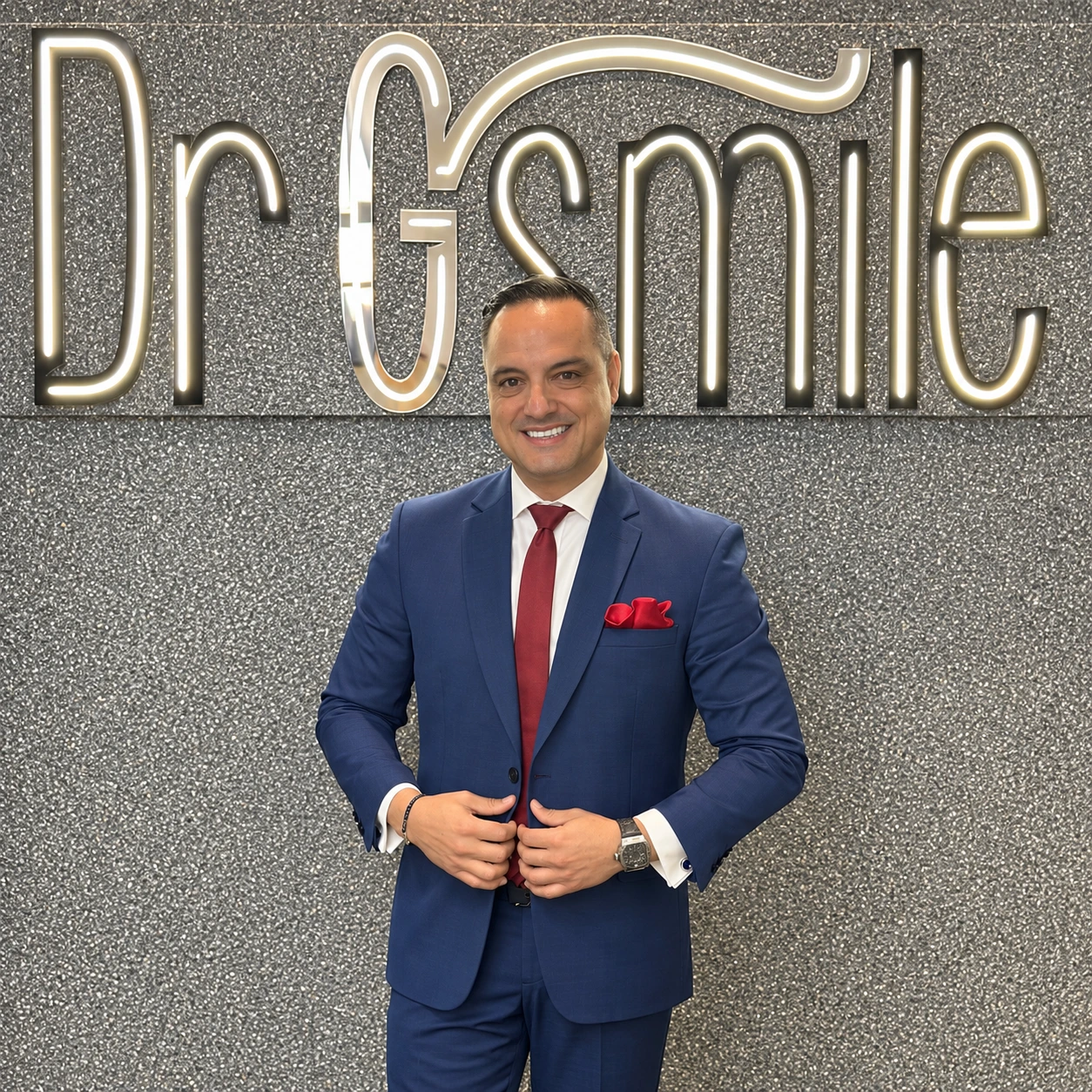 Retrato del Dr. Raúl González frente al emblema DrGsmile